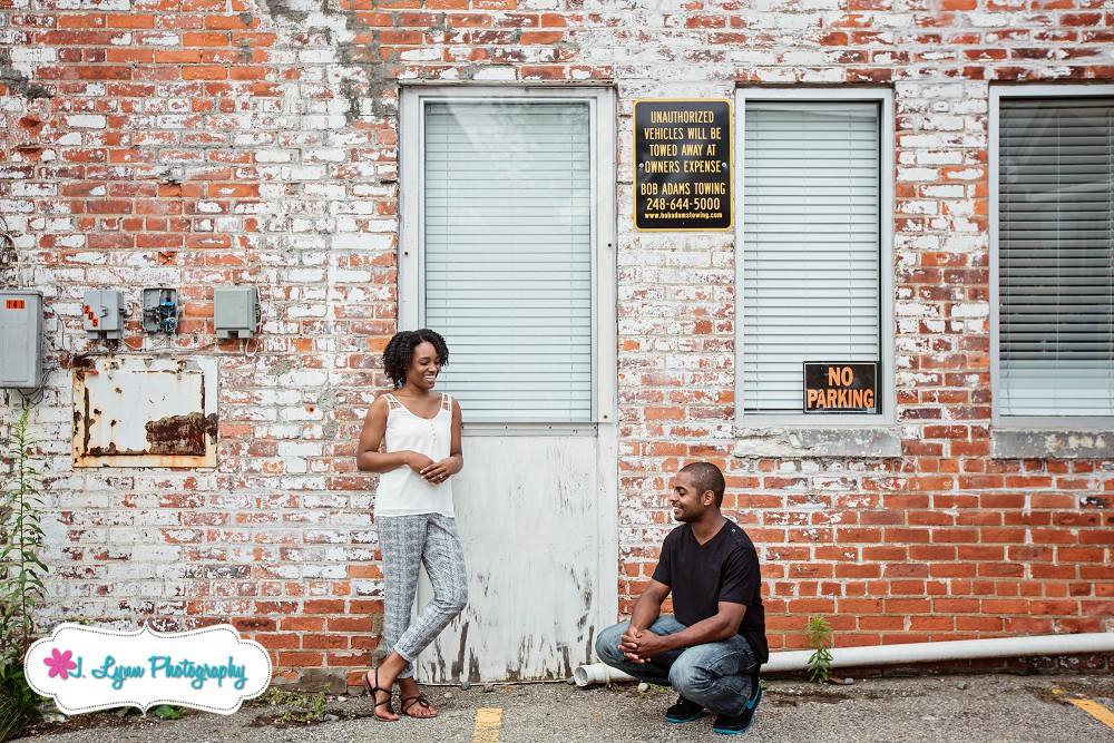 couple standing against brick wall