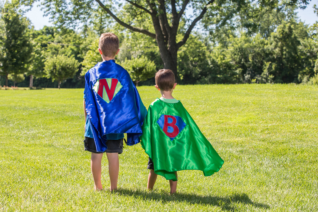 Brothers in matching superhero capes