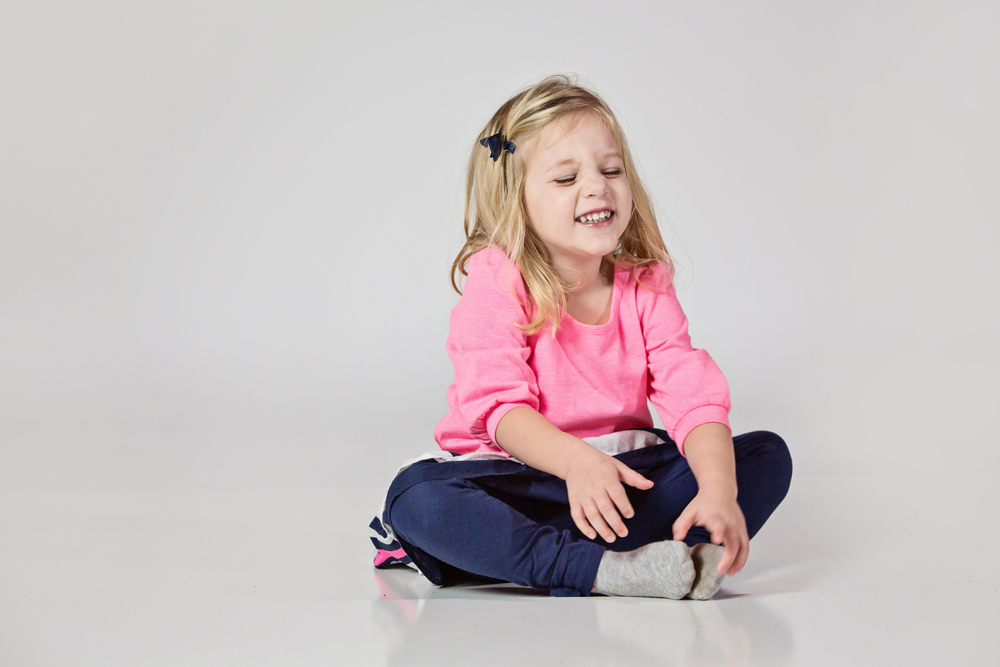 Girl laughing during photo session in studio