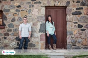 couple standing in front of old farm building