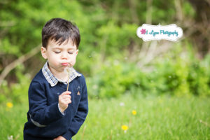 Boy blowing on dandelion at park