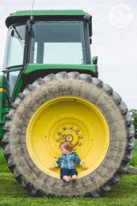 boy sitting in tractor tire