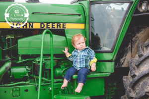 boy sitting on tractor on a farm