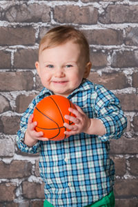 Little boy smiling while holding basketball